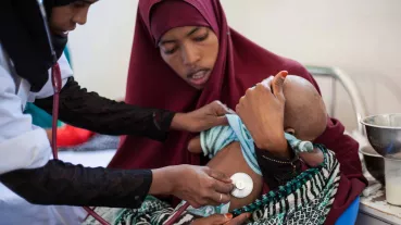 Image: A health worker examines a girl.